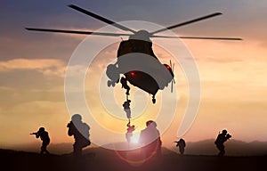 Special force assault team helicopter drops during sunset