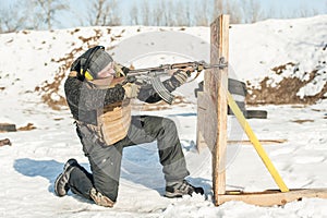 Special forces soldier in action, shooting from rifle machine gun