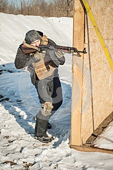 Special forces soldier in action, shooting from rifle machine gun