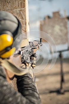 Special forces soldier in action, shooting from rifle machine gun