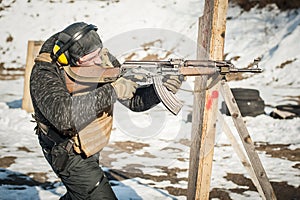 Special forces soldier in action, shooting from rifle machine gun