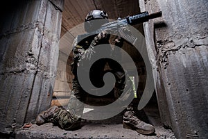 Special forces soldier aiming a rifle in dark room