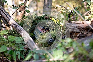 Special forces, soldier assault rifle with silencer, optical sight. behind cover waiting in ambush