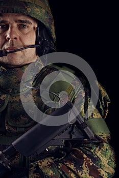 Special forces soldier with rifle on dark background