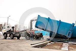 A special heavy machine loads a container with sorted waste.