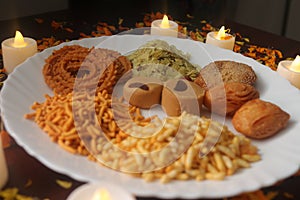 Indian Tasty Mix Snacks Plate. Candlelights. Mixed food. Traditional India tasty snacks. Season of festivals.