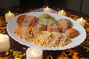 Indian Tasty Mix Snacks Plate. Candlelights and Petals. Mixed food. Traditional India tasty snacks. Season of festivals.