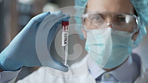Special laboratory employee showing experimental Ebola virus vaccine, healthcare