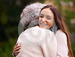 The special love between a mother and daughter. a woman embracing her senior mother outdoors.