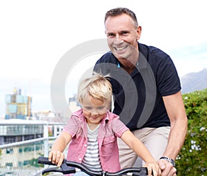 Special moments. A handsome father teaching his young son how to ride a bike.