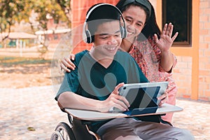 Special need child on wheelchair use a tablet in the house with his parent, Study or Work at home
