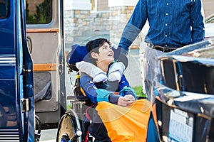 Special needs boy in wheelchair on vehicle handicap lift