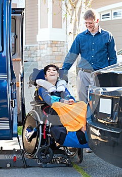 Special needs boy in wheelchair on vehicle handicap lift