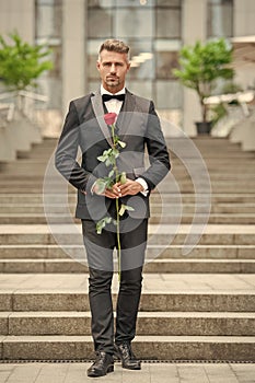 special occasion formalwear. caucasian man with rose for special occasion. tuxedo man outdoor