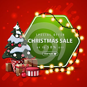 Special offer, Christmas sale, up to 50% off, square red and green banner with hexagonal sign wrapped garland and Christmas tree