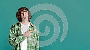 Special offer. Excited youth pointing aside on turquoise background, empty space for design. Panorama