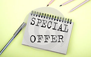 SPECIAL OFFER text on the notebook with pen on yellow background