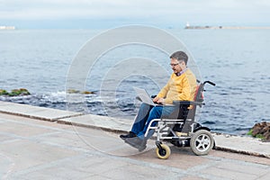 a special person with disabilities with a laptop at sea