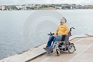 a special person with disabilities looks at the sea walk