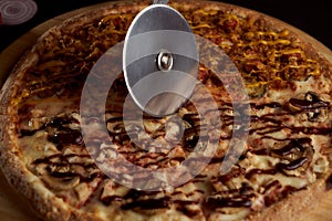 A special pizza knife cuts it into pieces. closeup