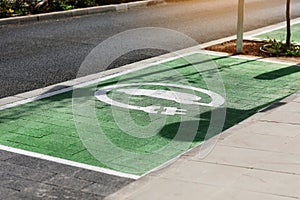 Special place for charging electric cars or vehicles. Green E- Car charging station sign in a parking bay. Modern and
