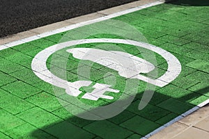 Special place for charging electric cars or vehicles. Green E- Car charging station sign in a parking bay. Modern and