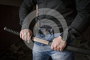 A special police officer holds a pistol, a sword and a grenade in his hands