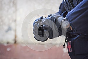 A special police officer holds a pistol, a sword and a grenade in his hands