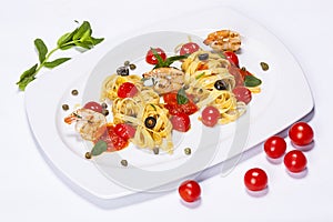 Special shrimp pasta dish made by restaurant chef with tomatoes and olives shot on white background