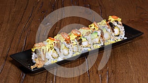 Special sushi roll with roasted eel, shrimp in tempura, cherry tomatoes, mayonnaise, omelette and sesame