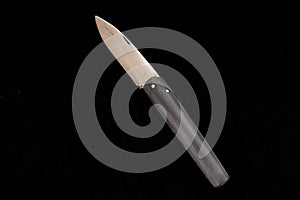 A special turkish knife. testing the sharpness of the blade on the black floor. a small pocket knife, a small shepherd`s knife,
