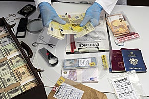 Specialised police officer Counting euro banknotes in crime lab photo