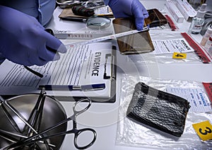 Specialised police officer measures wallet in crime lab