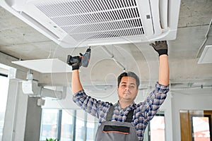 specialist cleans and repairs the wall air conditioner