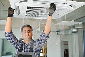 specialist cleans and repairs the wall air conditioner