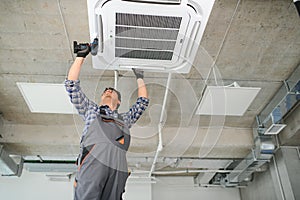 specialist cleans and repairs the wall air conditioner