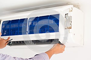 Specialist cleans and repairs the wall air conditioner