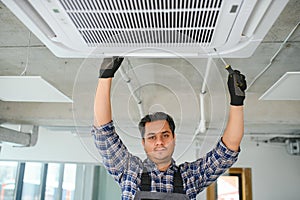 specialist cleans and repairs the wall air conditioner