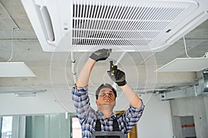 specialist cleans and repairs the wall air conditioner