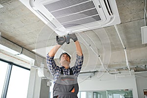 specialist cleans and repairs the wall air conditioner