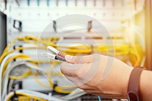 IT specialist connects fiber optic cables to the network equipment. IT infrastructure