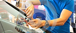 Specialist fixing crack on car windshield in repair shop