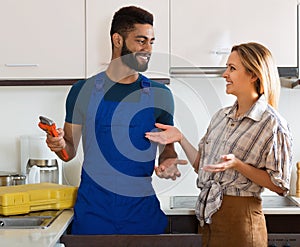 Specialist fixing leaky faucet, pleased cheerful blonde