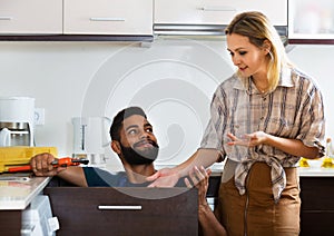 Specialist fixing leaky faucet, pleased cheerful blonde