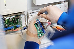 Specialist hands connect the wire to the Board with chips. Repair, maintenance and adjustment of instrumentation and equipment