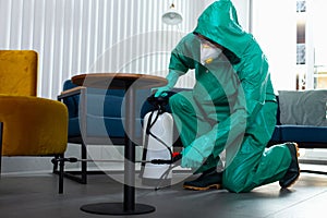 Specialist in hazmat suit disinfecting the apartment during pandemic