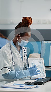 Specialist holding tablet with bones for orthopedic checkup