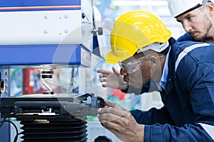 Specialist male African American engineer workers in manufacturing factory workplace.