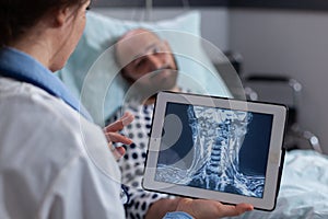 Specialist physician woman examining bones radiography using tablet computer