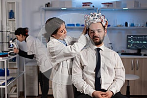 Specialist physician woman putting eeg headset on man patient monitoring brain evolution